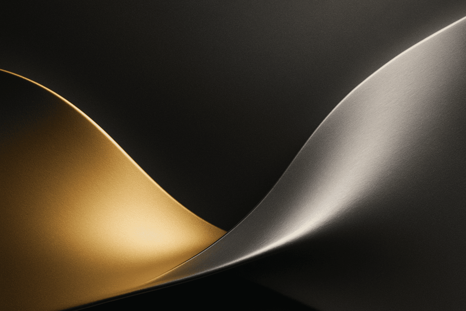 Abstract close-up of gold and silver metallic curves symbolising the contrast between gold and silver jewellery.